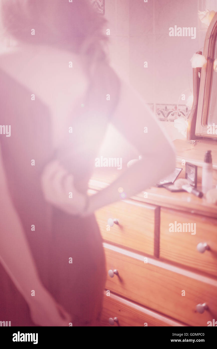Blur image of a woman zipping up her dress and getting ready to go out Stock Photo