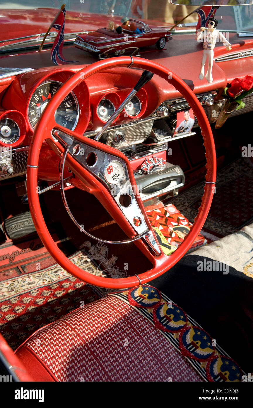 Steering wheel and dashboard of a red Cadillac Impala, previously owned by Jerry Lee Lewis, with Elvis memorabilia in the Stock Photo