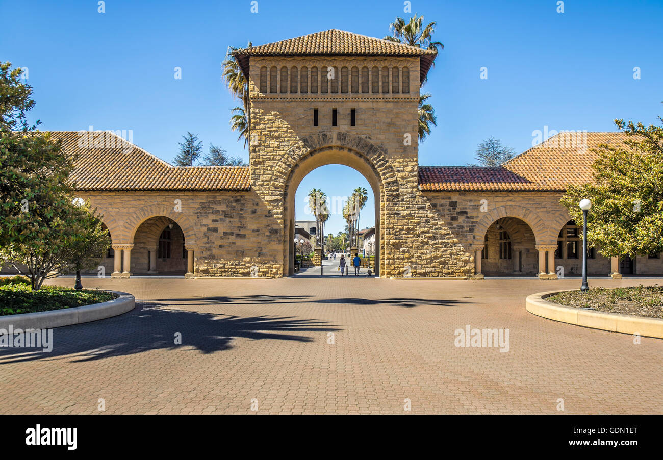 A Centered View of the Western Gate of Stanford University's Main Quad with a Sunny Sky and Tile Roofed Sandstone Buildings Stock Photo