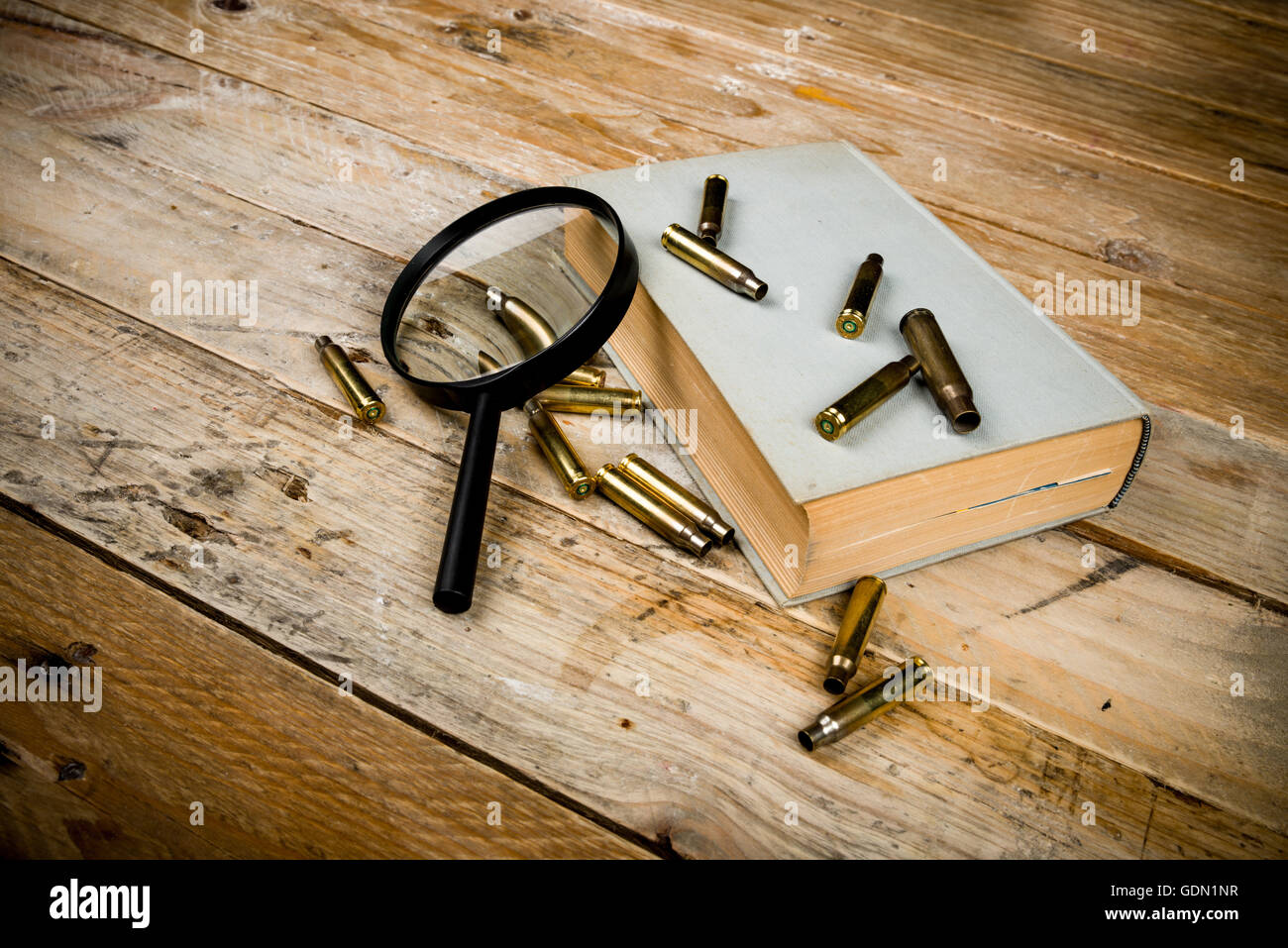 Detective novel concept  with book, bullets and magnyfying glass Stock Photo
