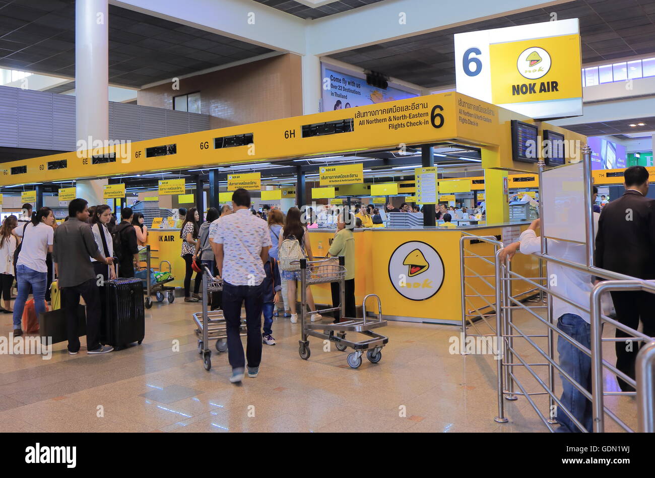 People check in for Nok Air flights at Don Mueang airport in Bangkok Thailand. Stock Photo
