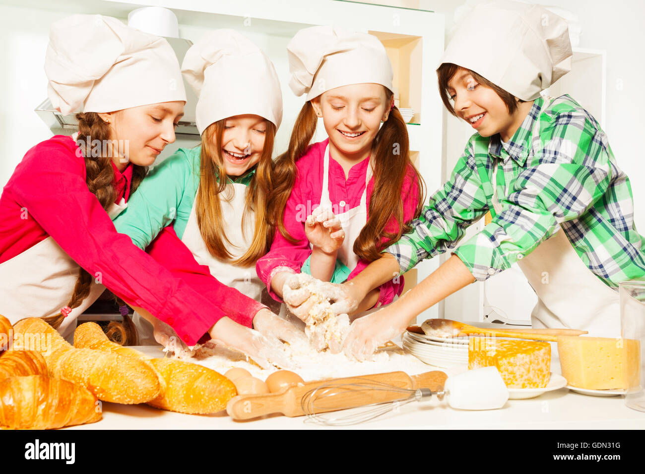 Four young bakers kneading dough at the kitchen Stock Photo Alamy