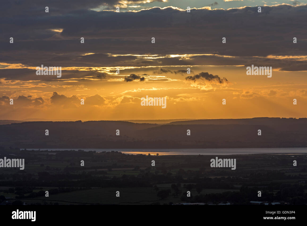 Sunset over Severn Estuary, looking west towards the Forest of Dean from Long Cam Down, Gloucestershire, England, UK Stock Photo