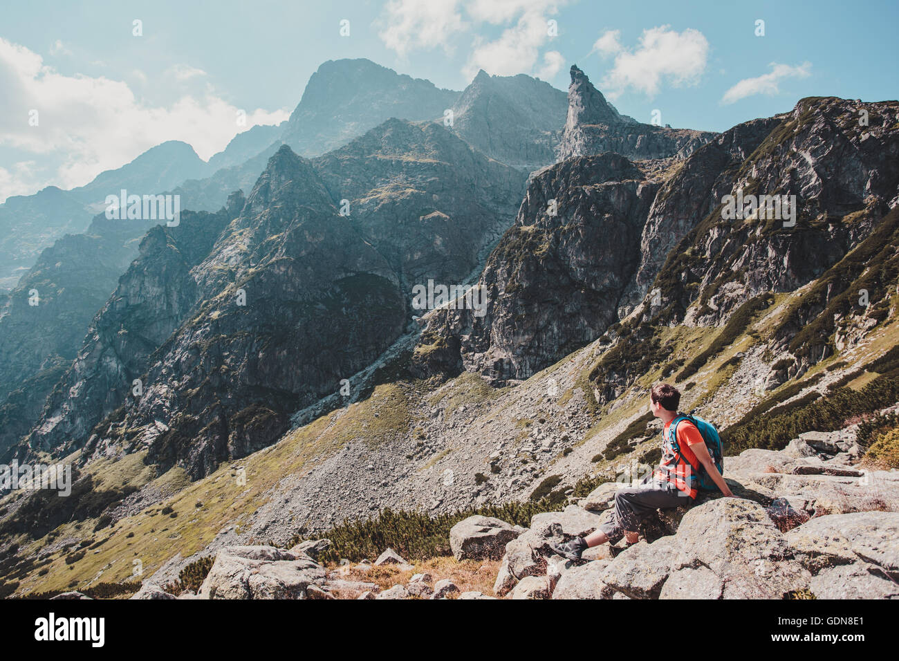Resting On Rocks Boy resting on a rock in the mountains Stock Photo - Alamy