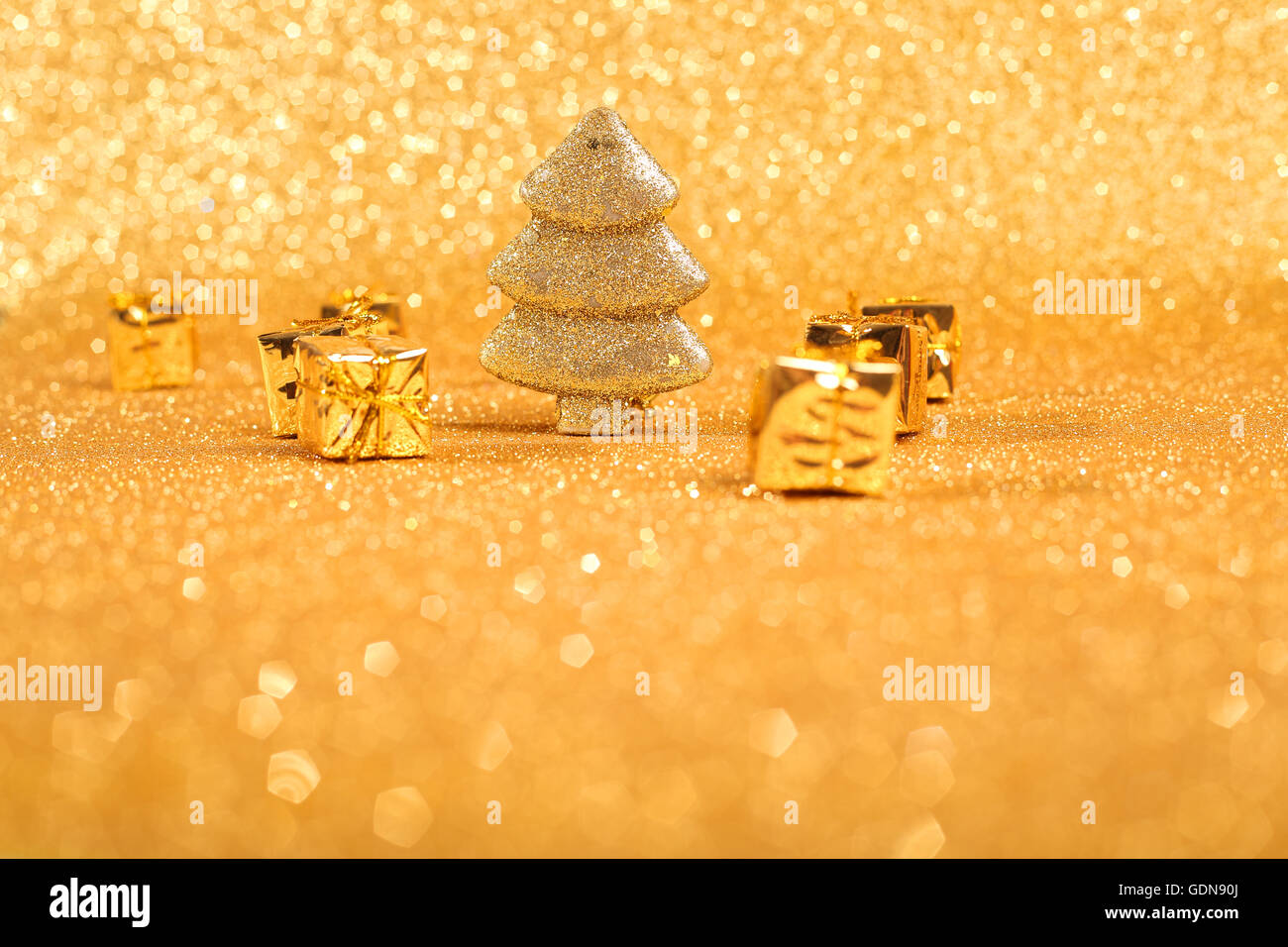 Golden christmas fir tree and gifts decoration on glitter background ...