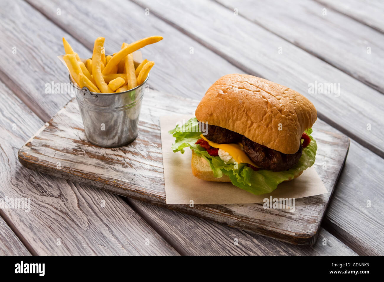 Burger and bucket of fries. Stock Photo