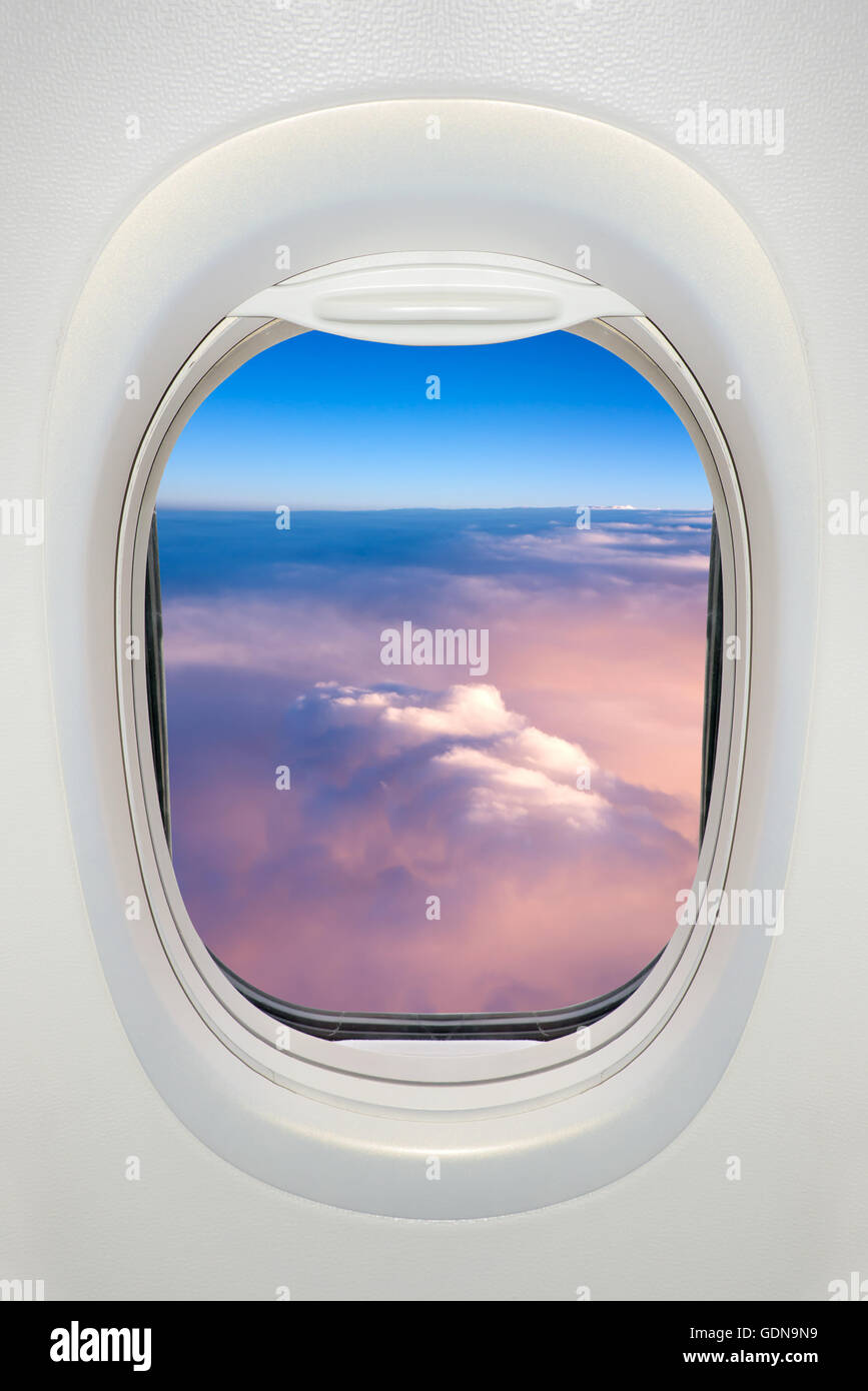 Window of an airplane from inside, view on a sea of clouds Stock Photo