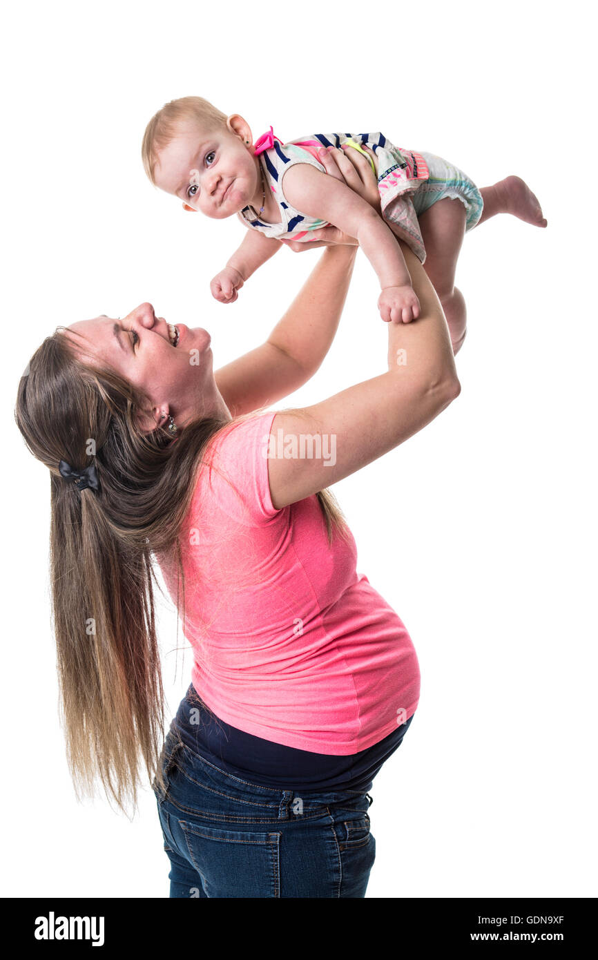 pregnant woman holding baby in the air over white background Stock