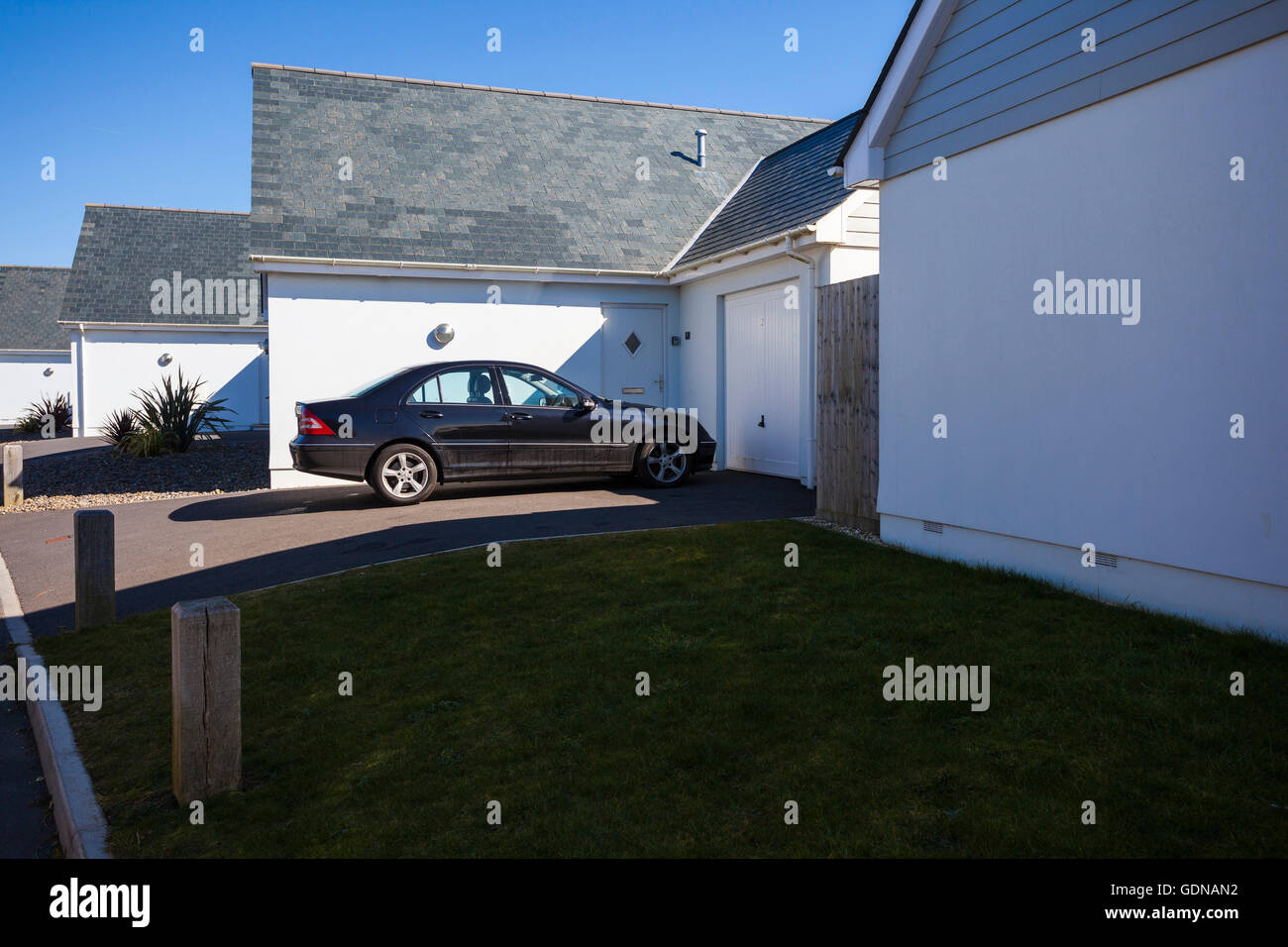 Modern housing estate with wooden panelled houses and black car parked