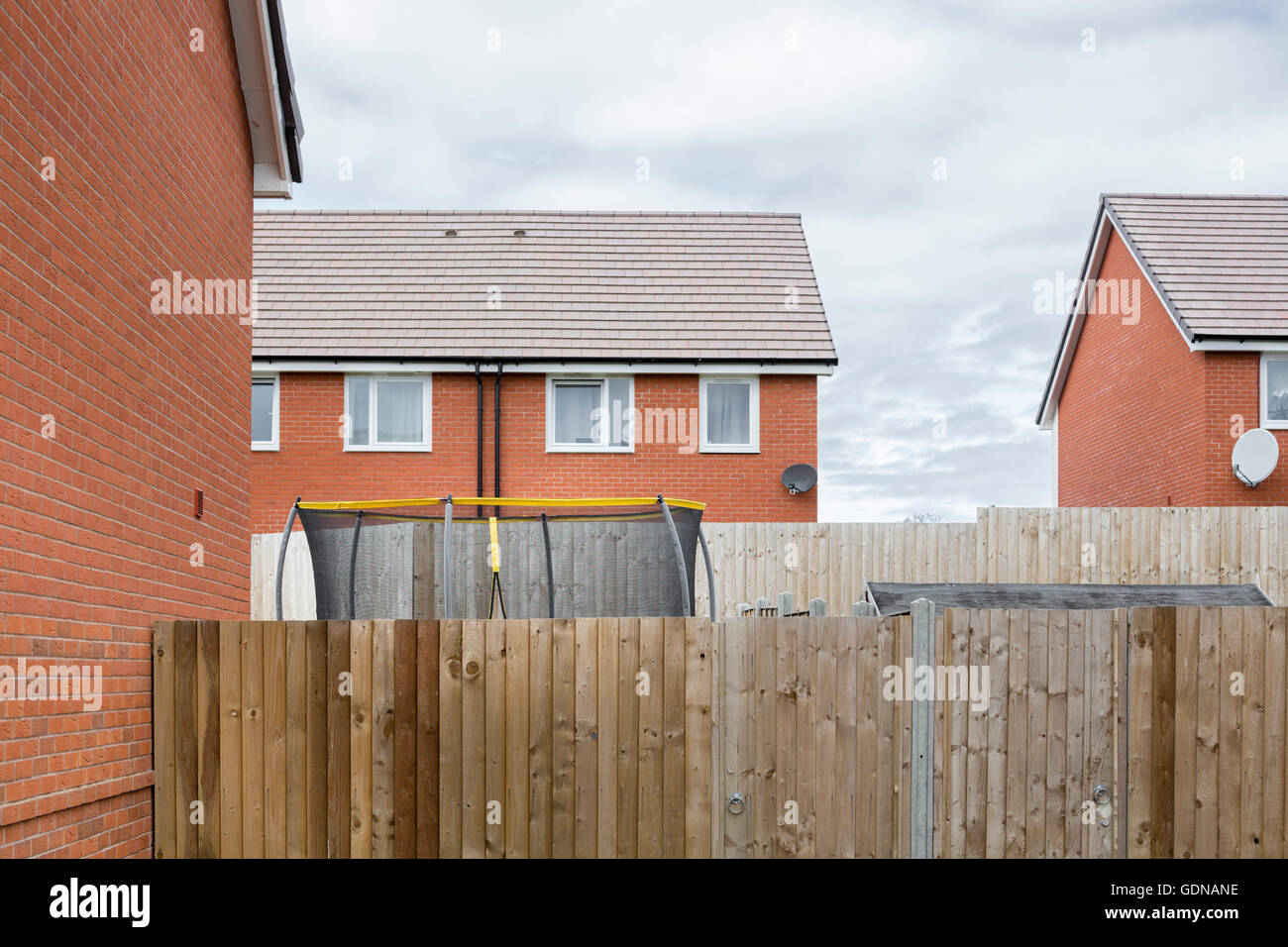 Suburban landscape, Bristol, UK with red brick house on a housing estate and garden with a childs trampoline. Stock Photo