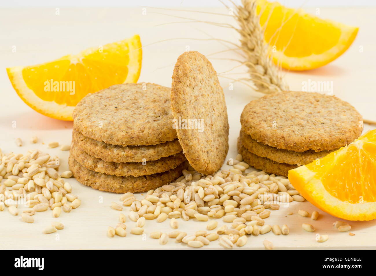Integral biscuits with orange and wheat seeds on white background Stock Photo