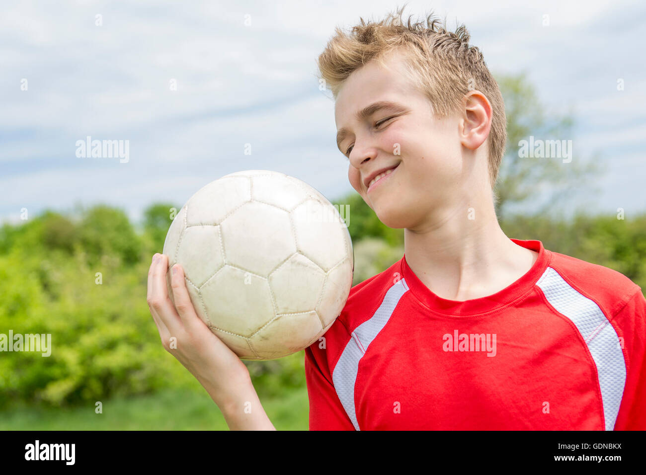 Active happy boy, having fun outdoor, playing football in sportive summer Stock Photo