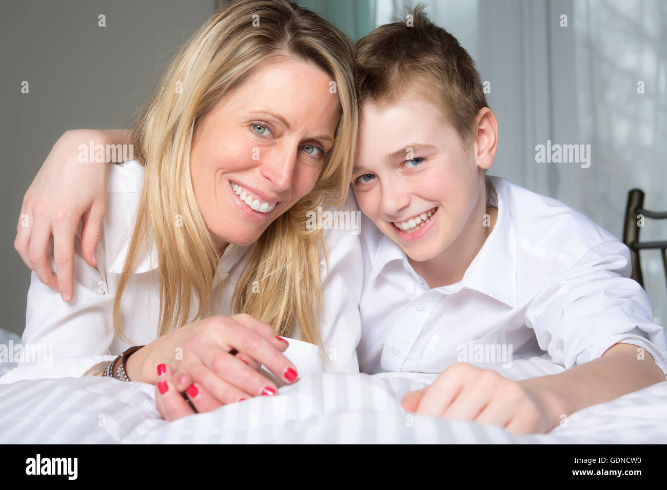 Mother And Son Relaxing Together In Bed Stock Photo