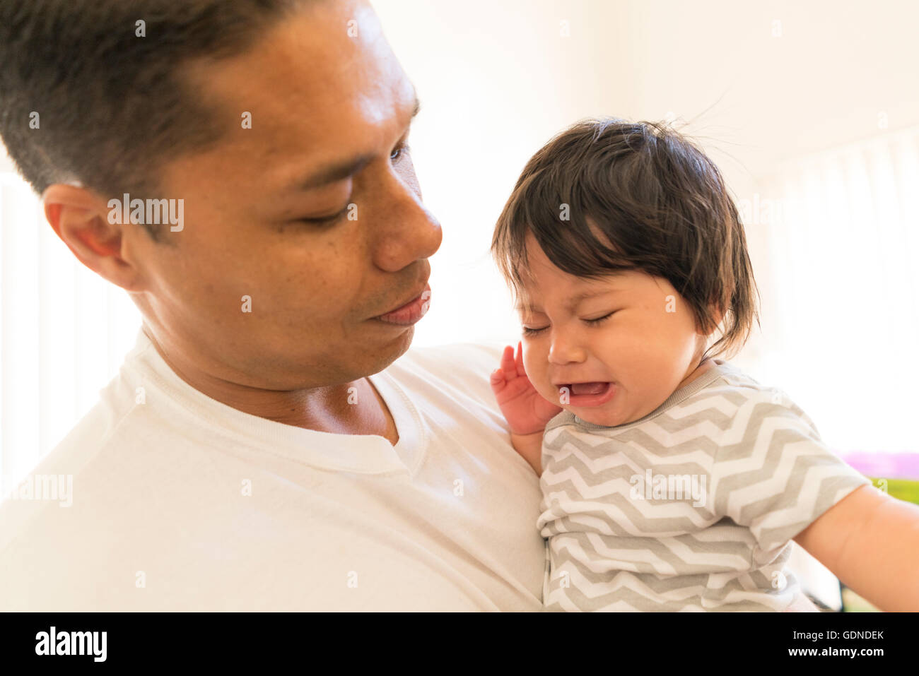 Father comforting crying baby Stock Photo