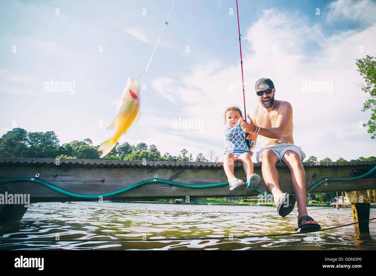 Father and daughter reeling in fish at Lake Jackson, Atlanta, Georgia, USA Stock Photo