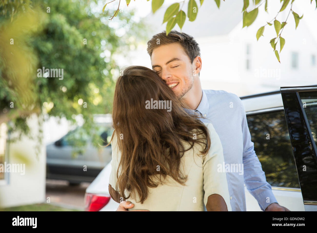 Young business couple kissing on street before leaving in car Stock Photo