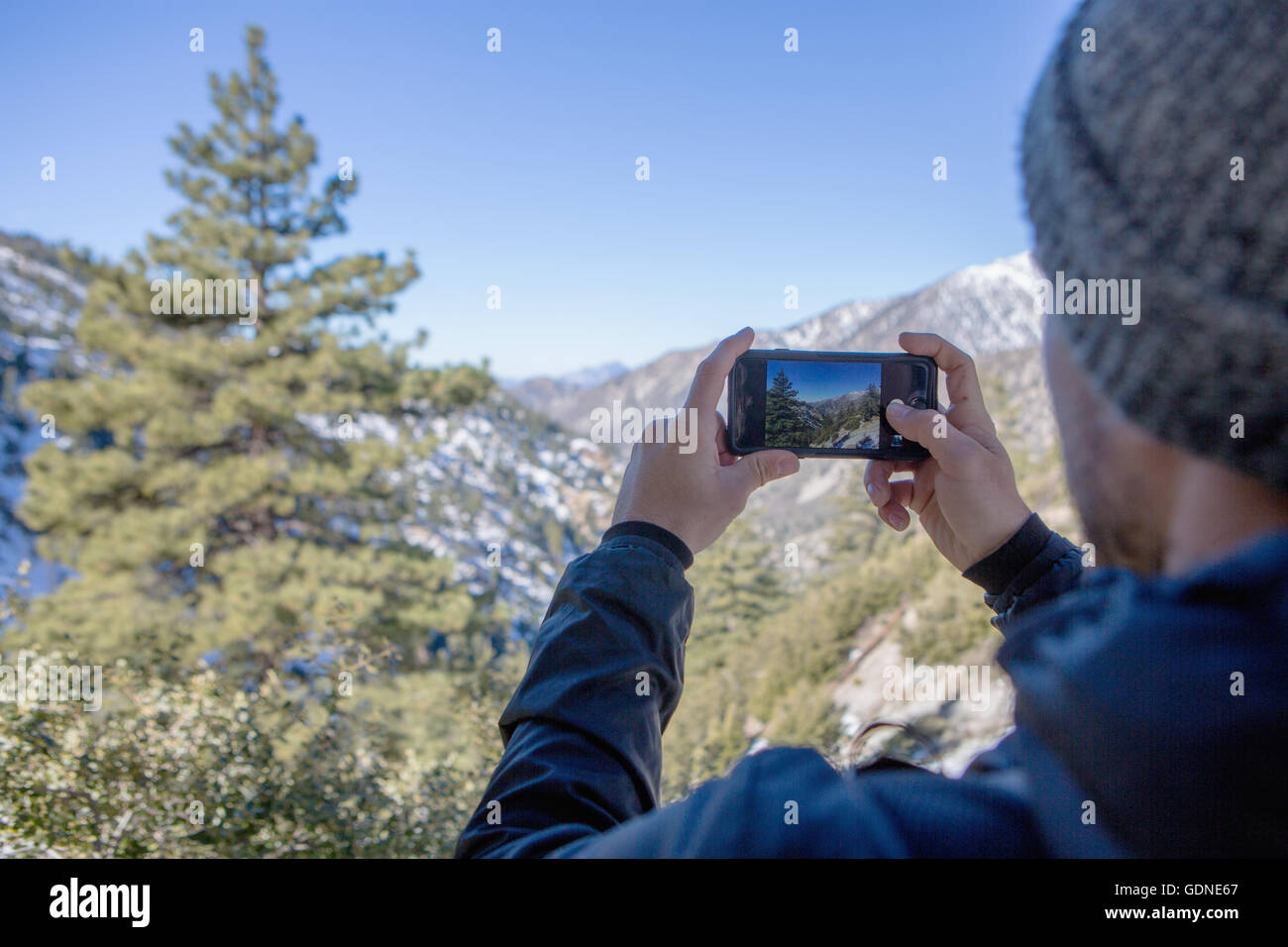 Hiker taking photograph of view, Mount Baldy, California Stock Photo