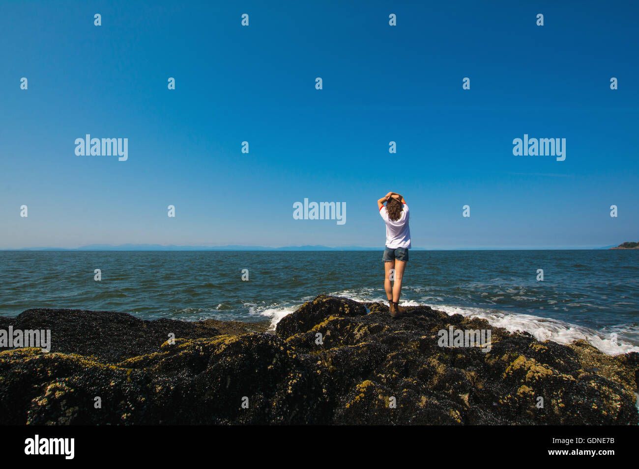 Woman standing at rocks hi-res stock photography and images - Alamy