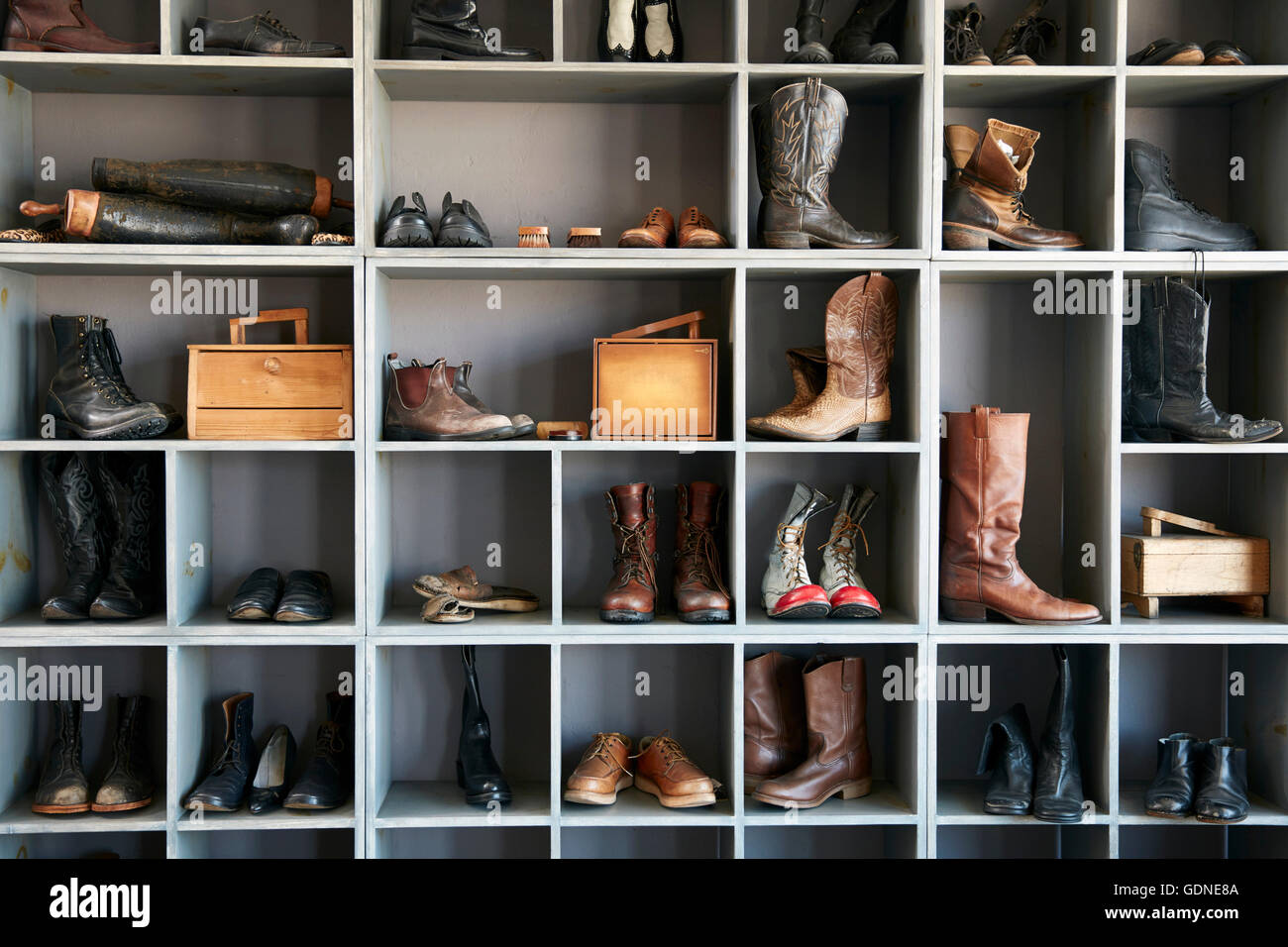 Display of boots and shoes on shelves in traditional shoe shop Stock Photo