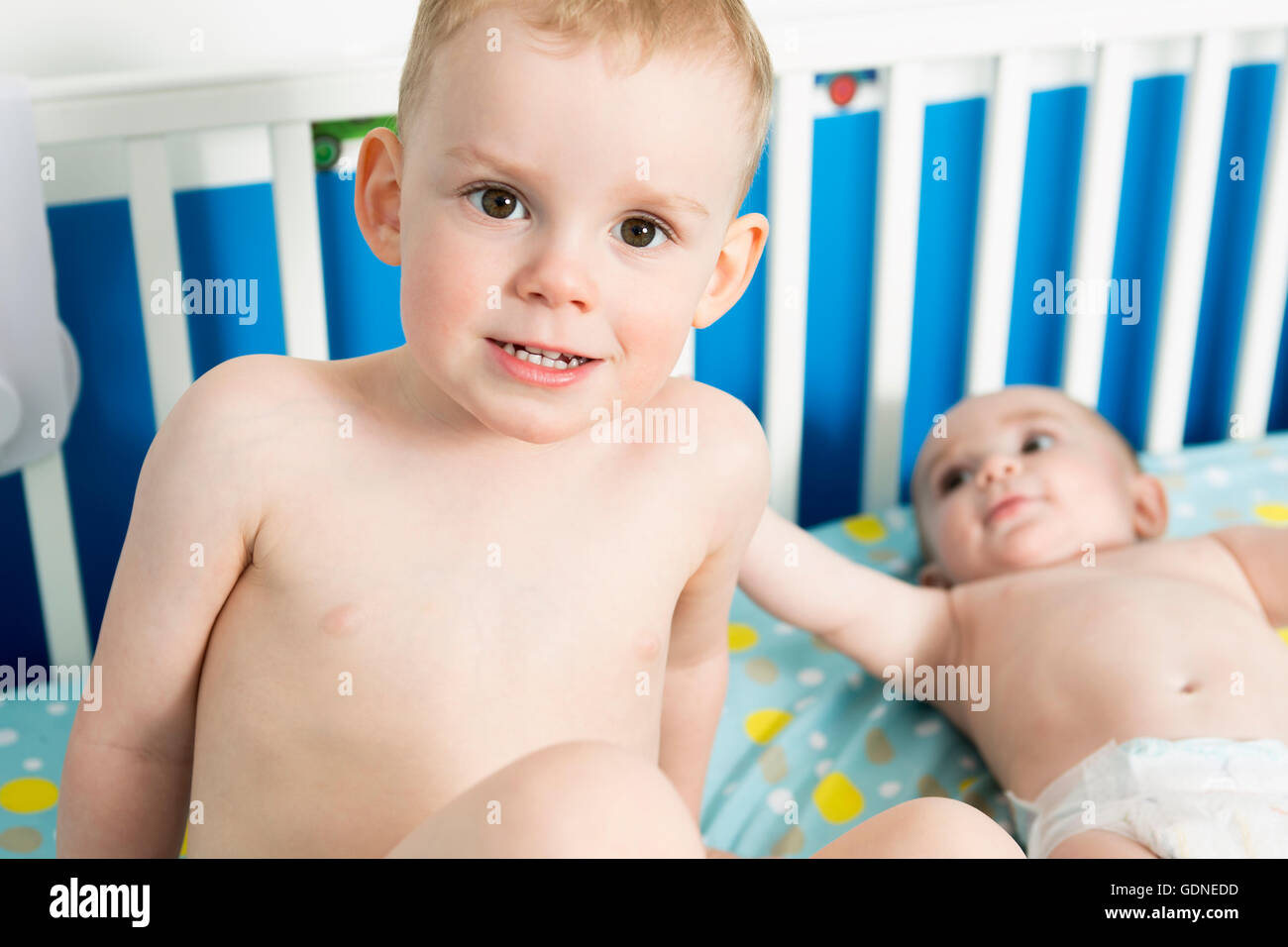 Cute Baby in Crib with his brother Stock Photo