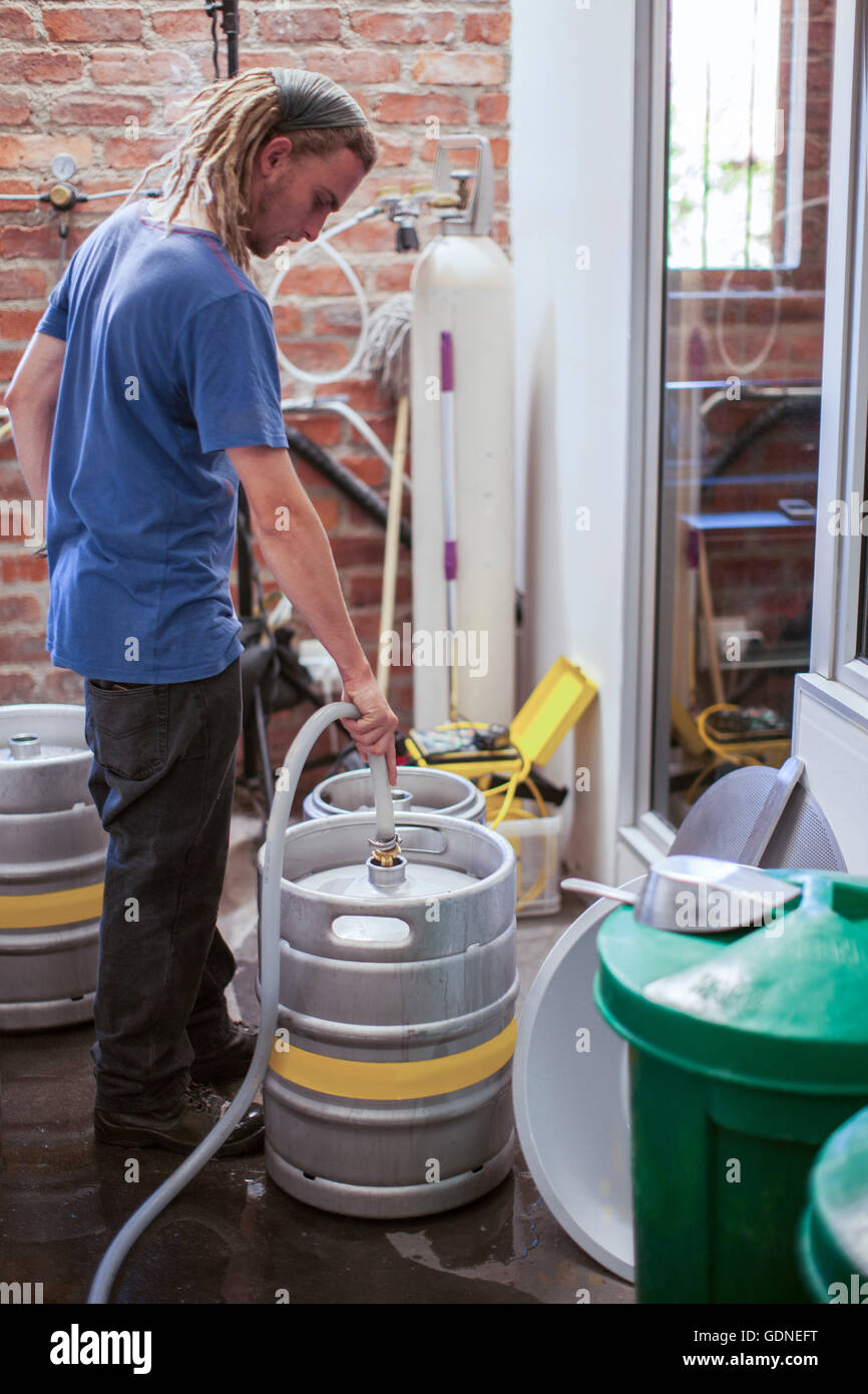 Man cleaning beer kegs in microbrewery Stock Photo