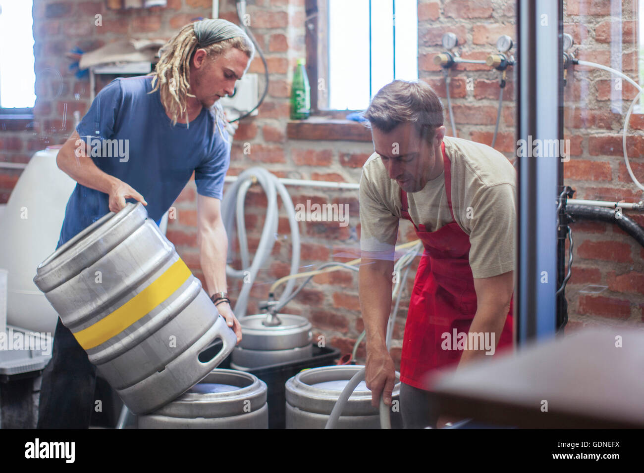 Colleagues in microbrewery cleaning beer kegs Stock Photo
