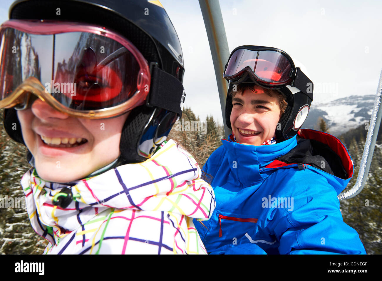 Teenage boy and girl on ski lift Stock Photo