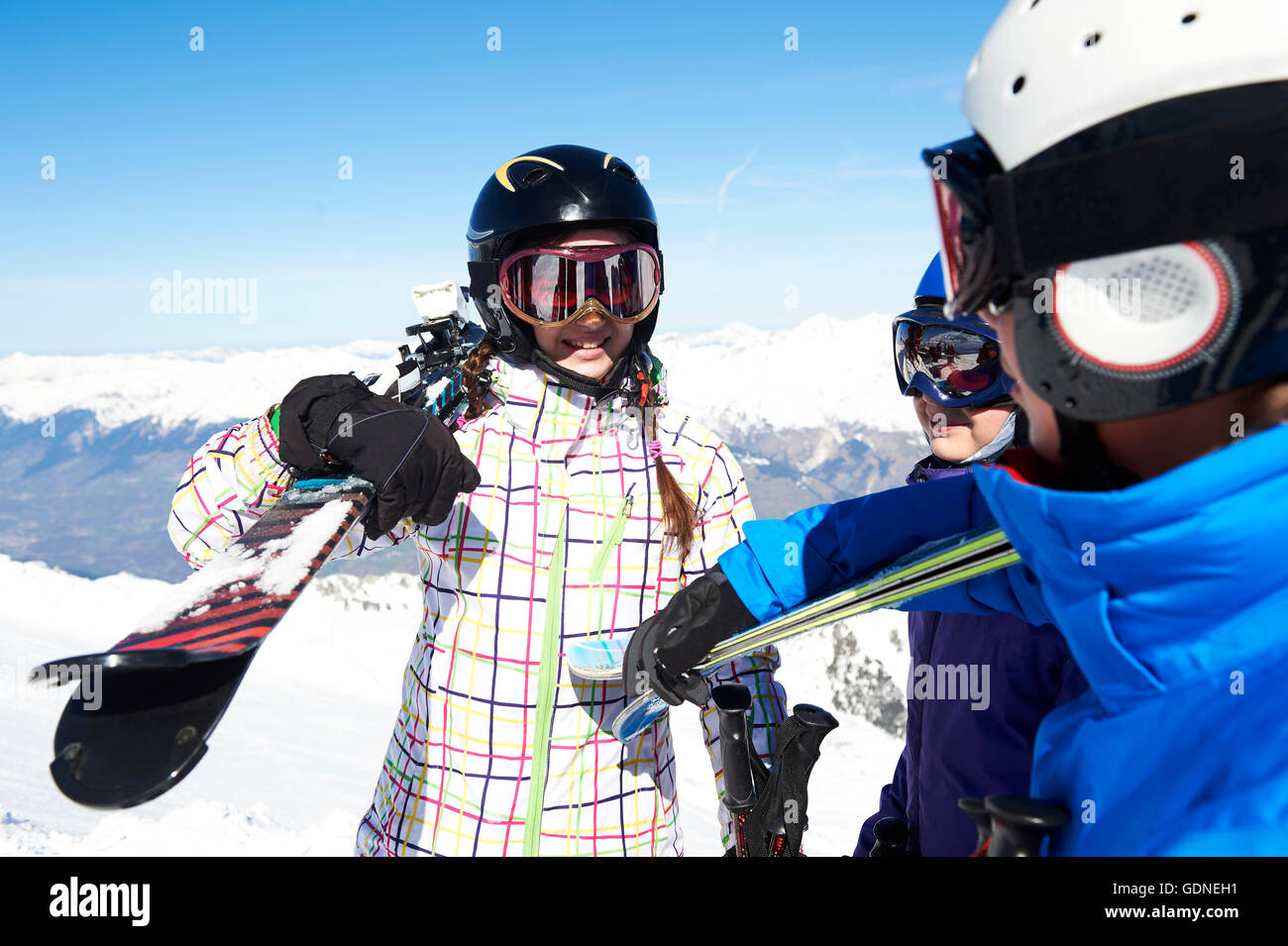 Three teenagers carrying skis Stock Photo