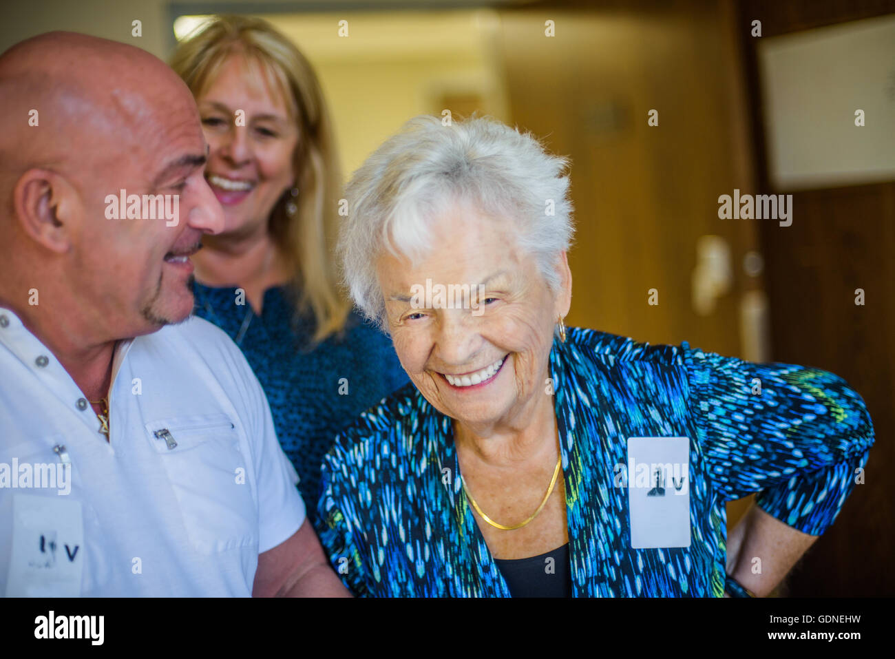Gray haired woman with friends laughing Stock Photo
