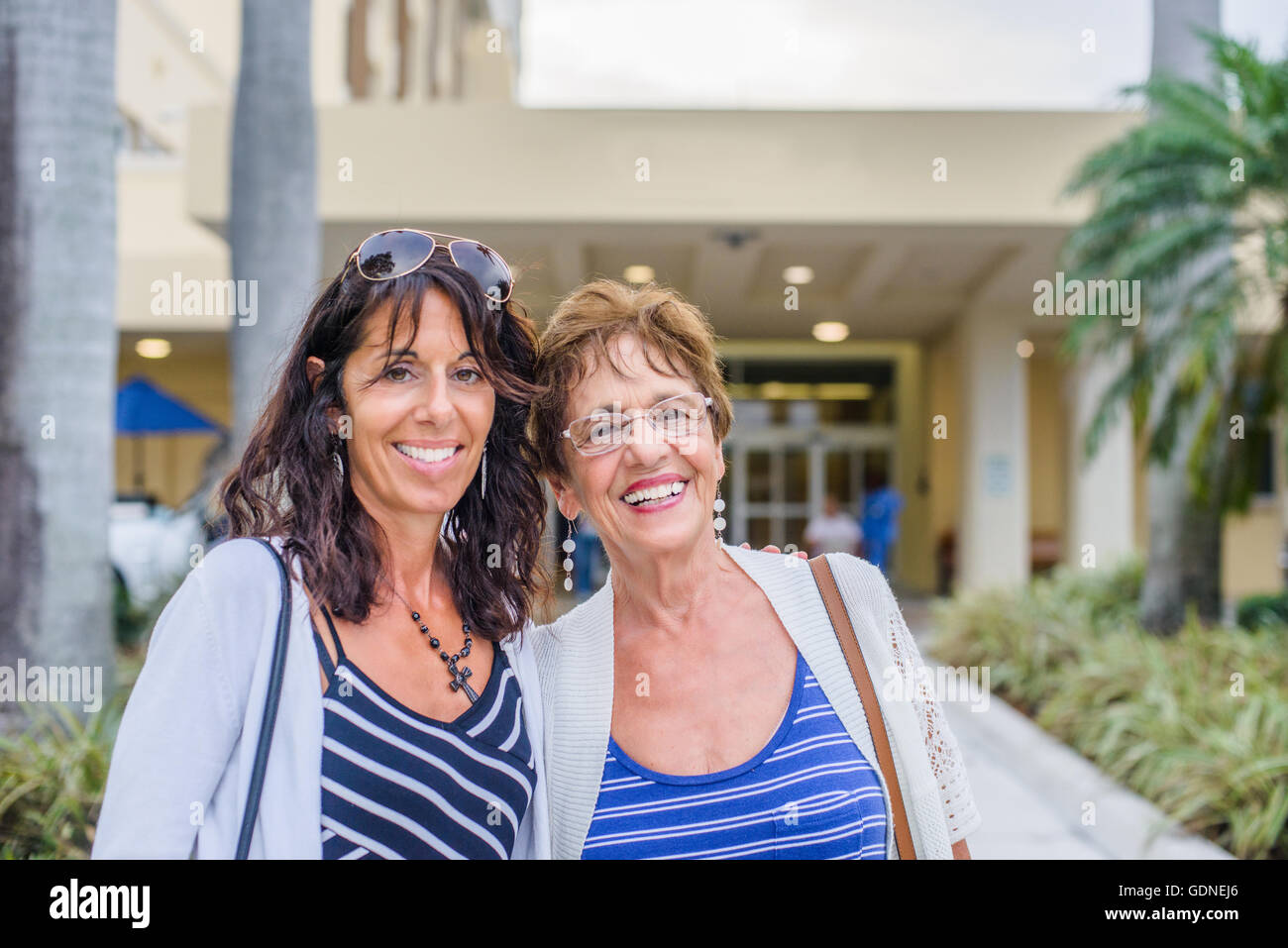 Mother and grown up daughter looking at camera smiling Stock Photo