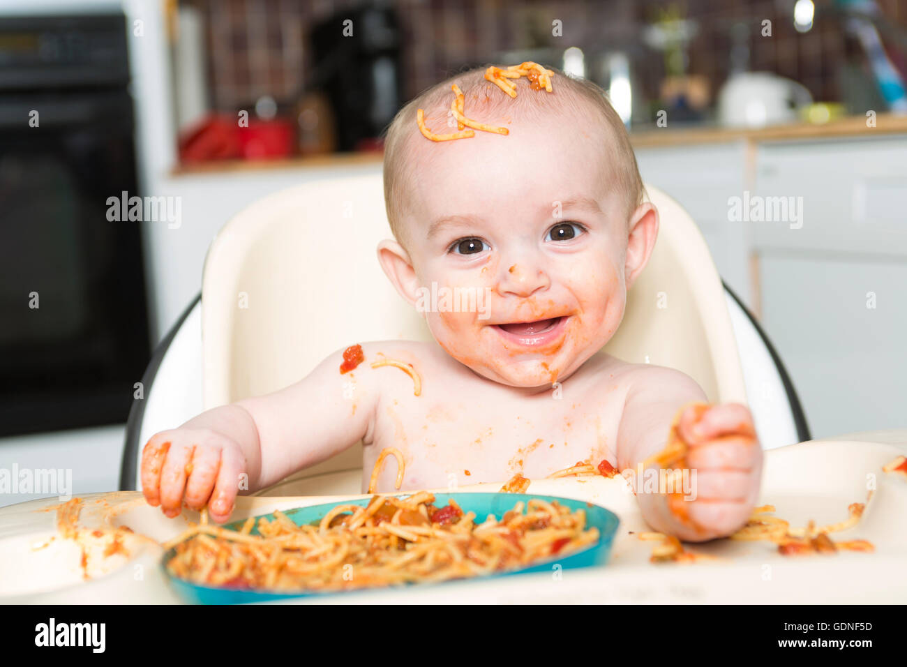 Little b eating her dinner and making a mess Stock Photo