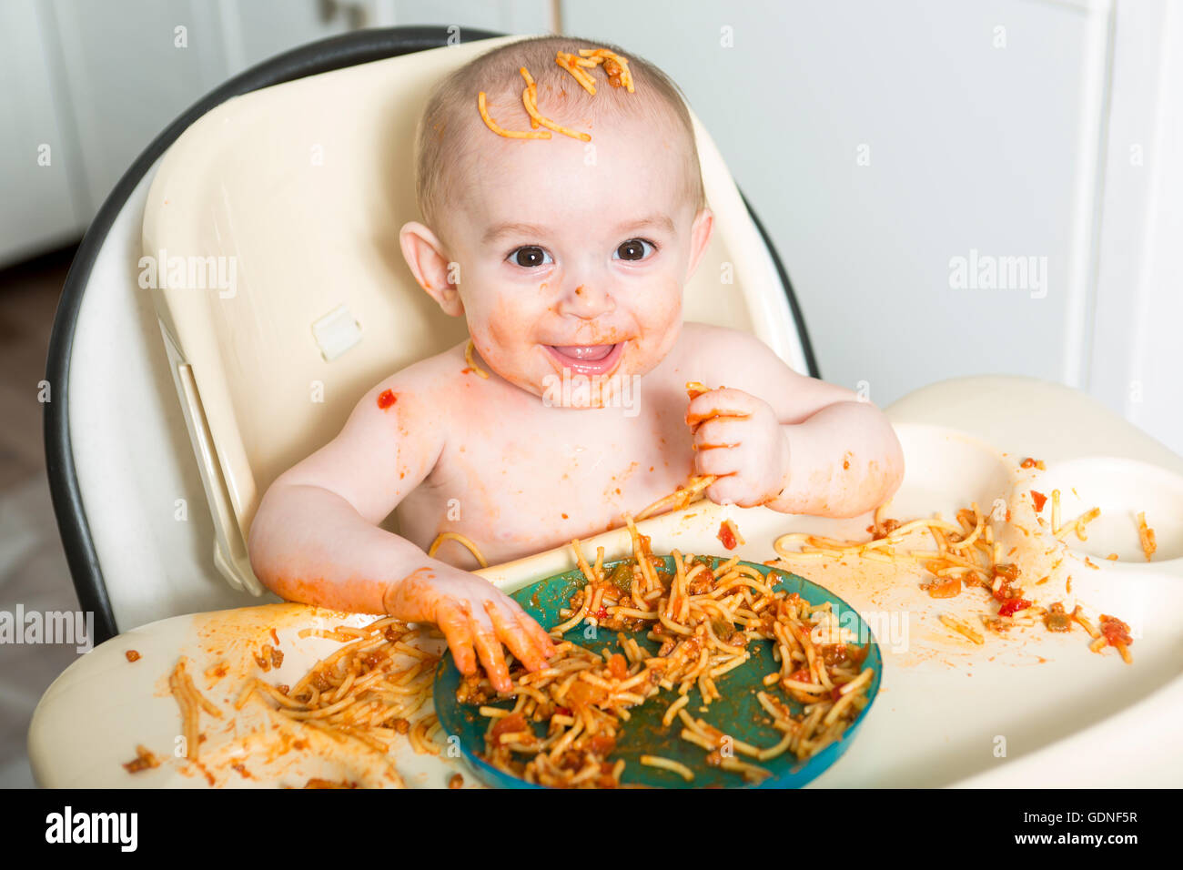 Little b eating her dinner and making a mess Stock Photo
