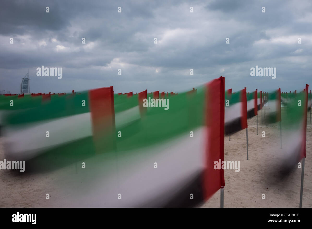 UAE flags on display for National Day on the Jumeirah Beach, with the iconic Burj al Arab in the background. Stock Photo