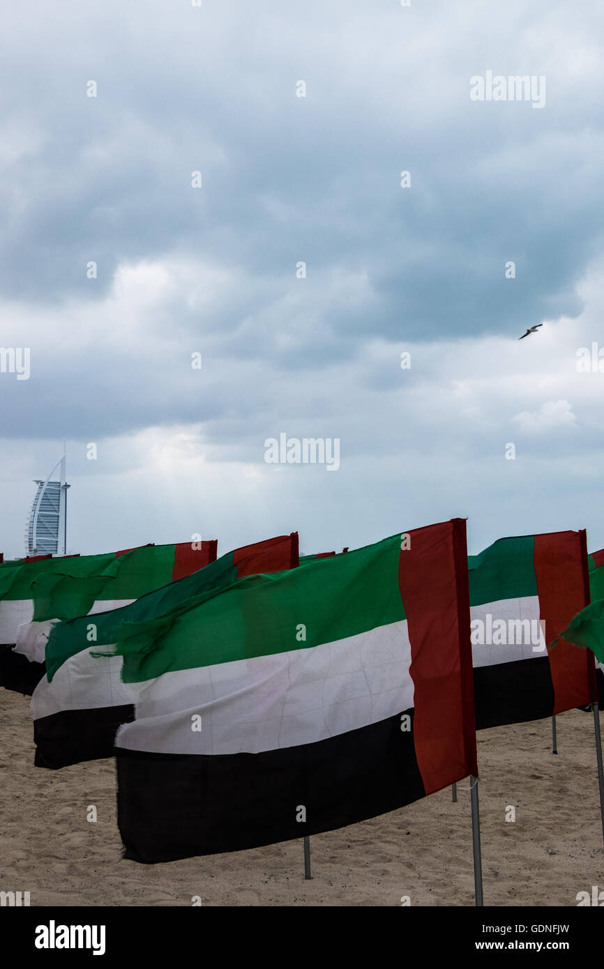 UAE flags on display for National Day on the Jumeirah Beach, with the iconic Burj al Arab in the background. Stock Photo