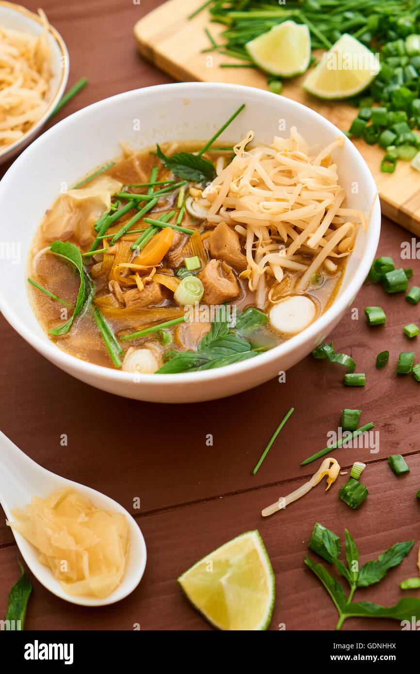 A bowl with thai vegeable soup, with ginger, lime and beansprouts Stock Photo
