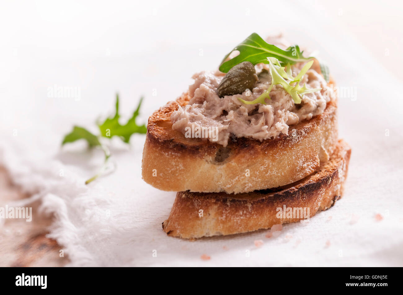 Fish pate spread with toast, capers and rucola close up Stock Photo Alamy