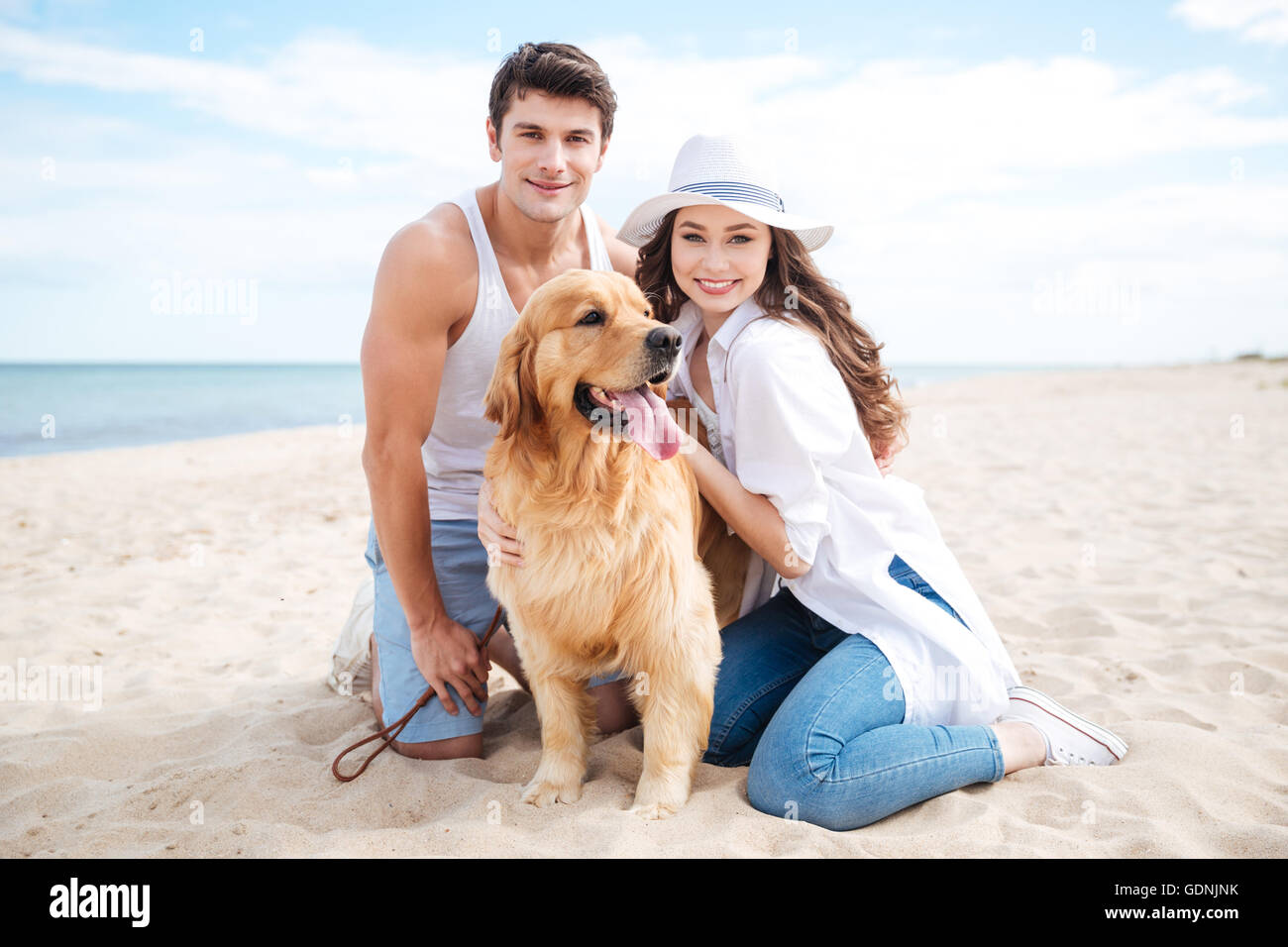 Beautiful young couple with their dog on the beach in summer Stock ...