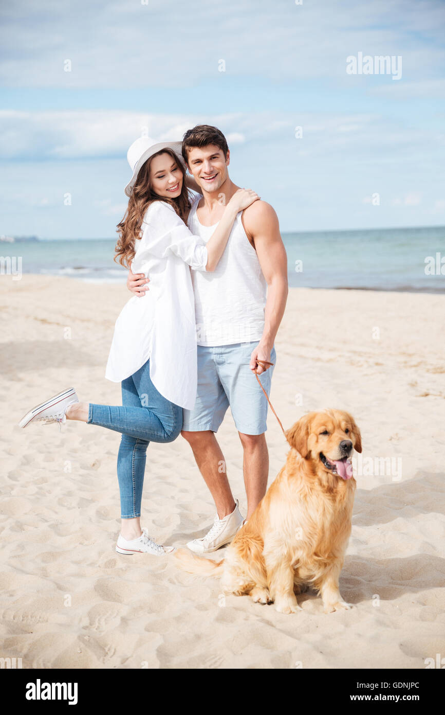 Full length portrait of happy young couple with dog on the beach Stock ...