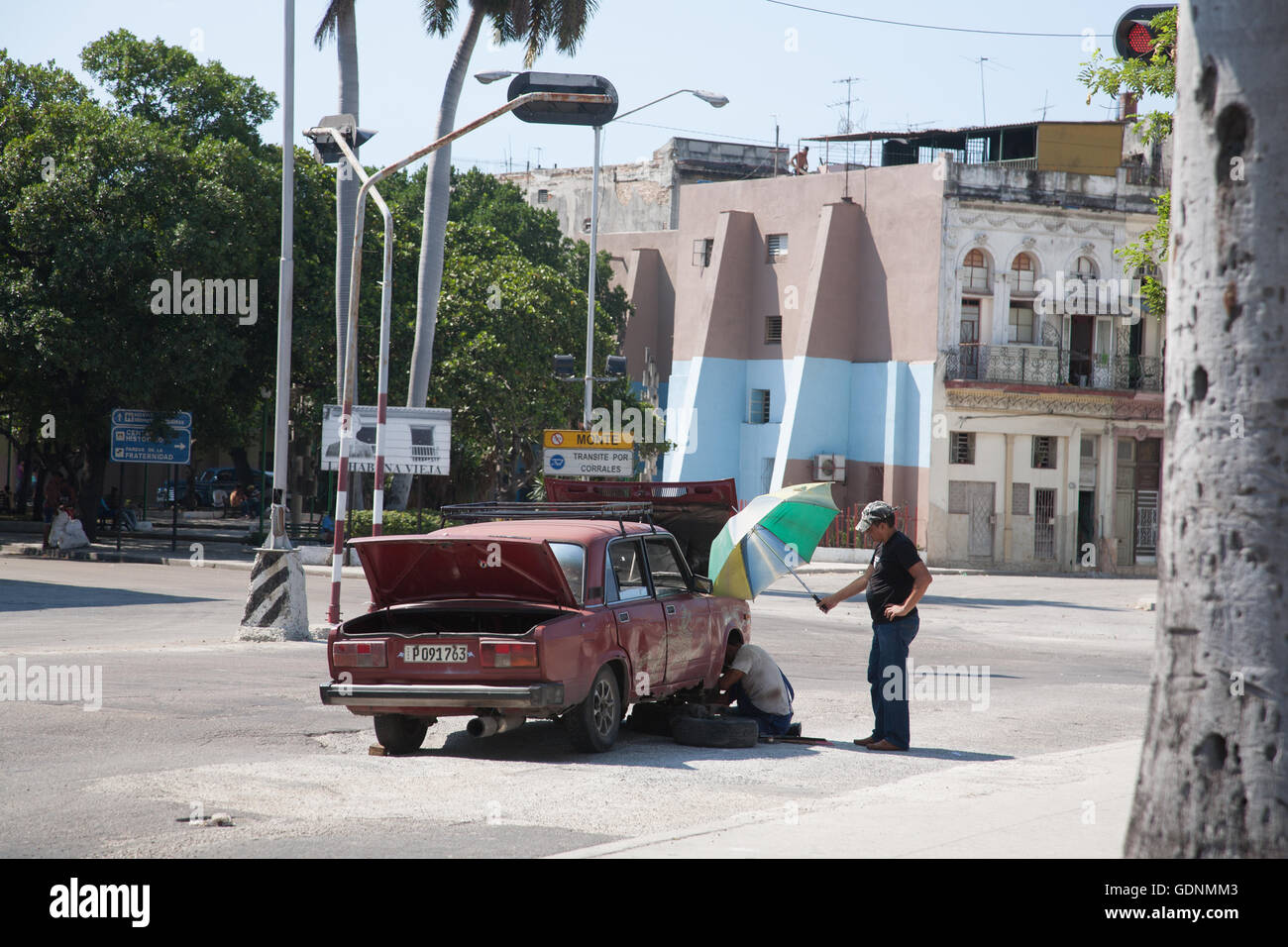 A broken-down Lada car is worked on my a mechanic a street in Havana, Cuba Stock Photo