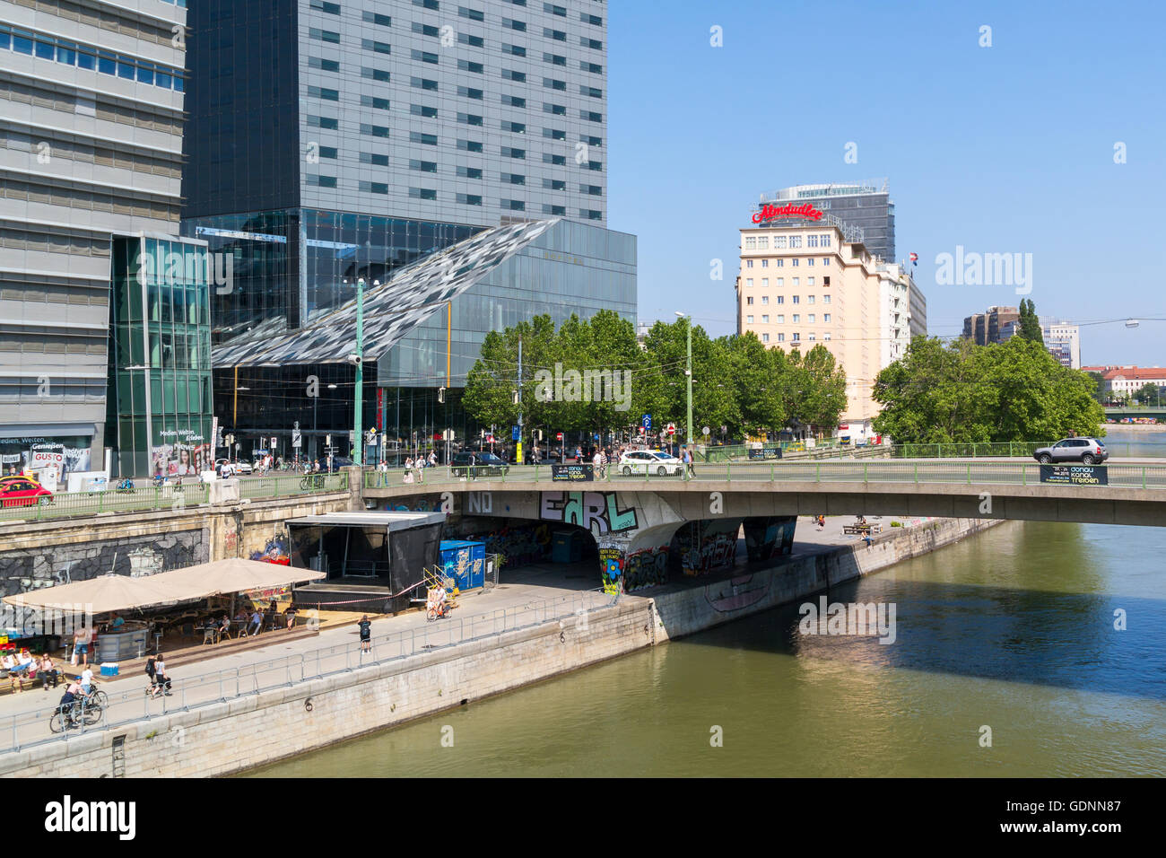 Highrise, waterfront cafes and Schweden bridge over Little Danube canal in city of Vienna, Austria Stock Photo