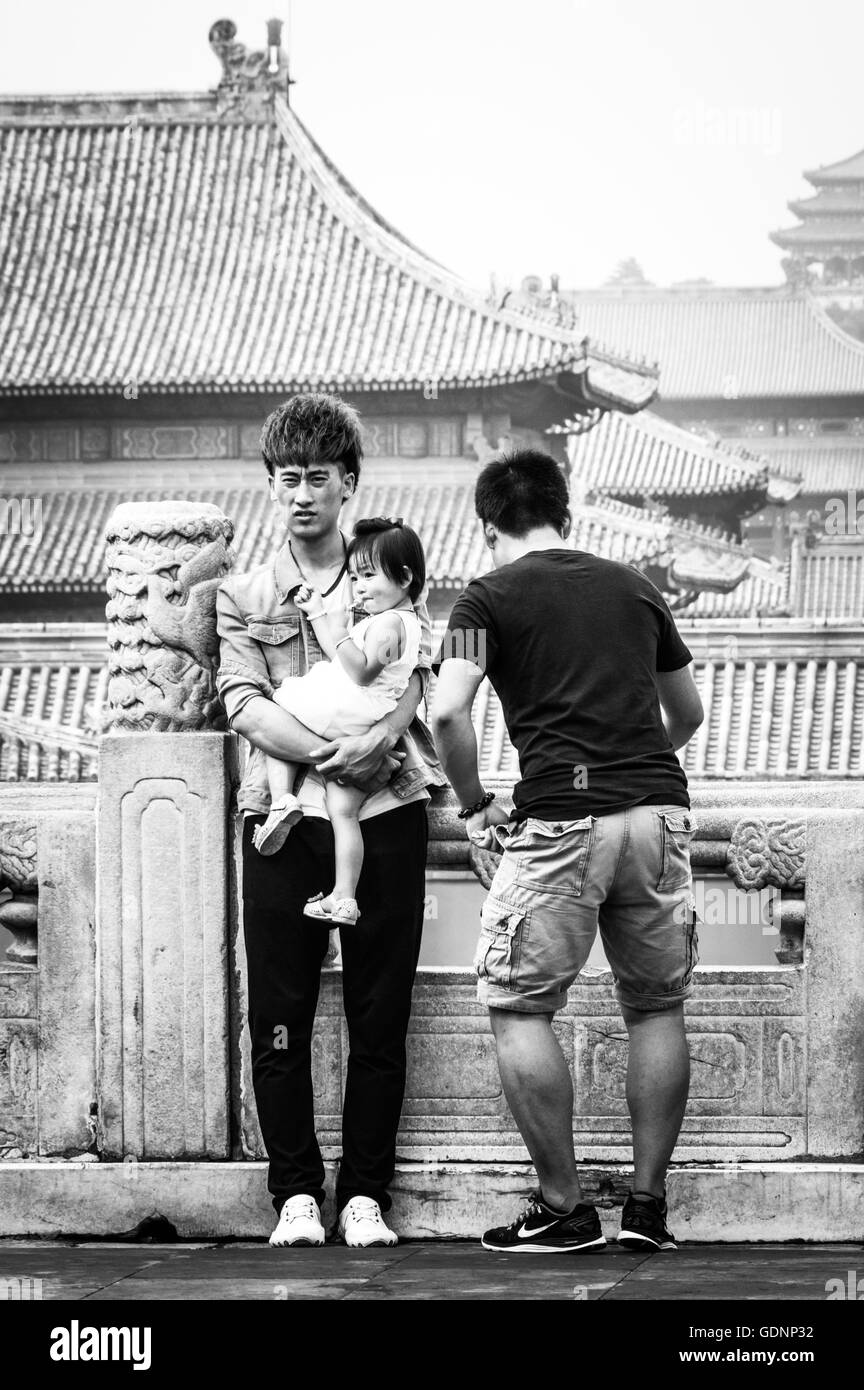 Front View of Young Chinese Men With Children Against Forbidden City Roofs Stock Photo