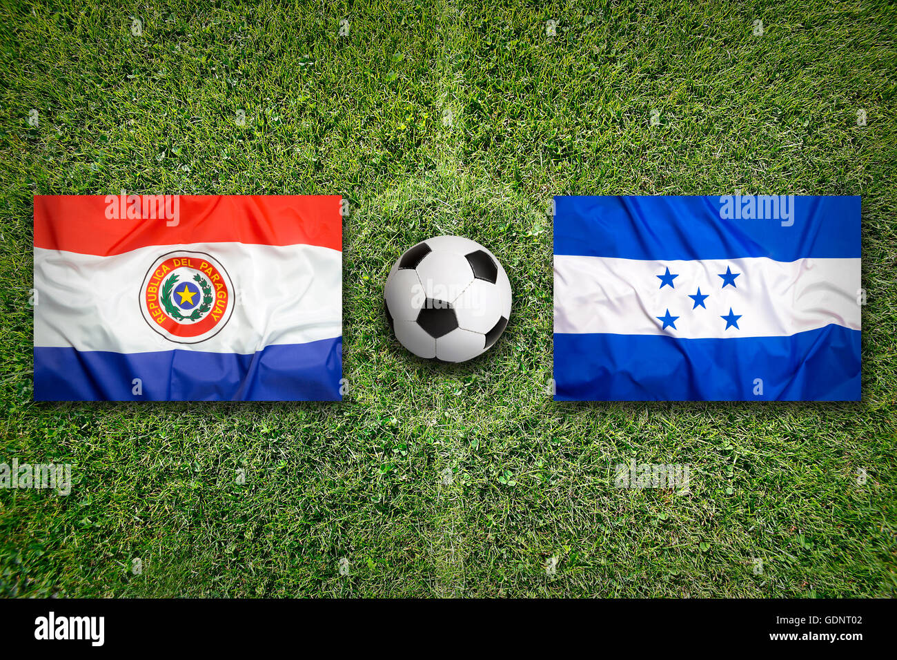 Paraguay vs. Honduras flags on green soccer field Stock Photo