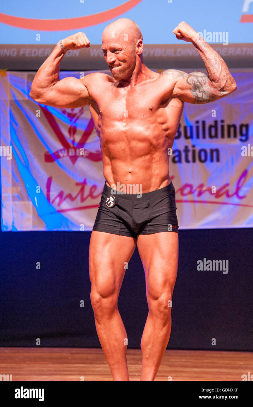 Body Builder Posing - Side Chest. Strong healthy power fitness handsome  athletic man with muscular trained body flexing his chest and biceps on  black Stock Photo - Alamy