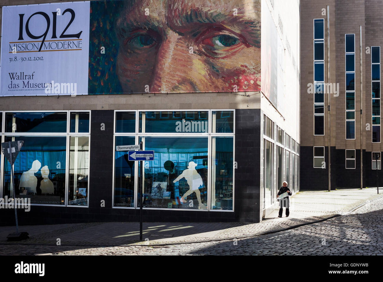 Pedestrians walk under the gaze of a poster of Vincent Van Gogh in the ...