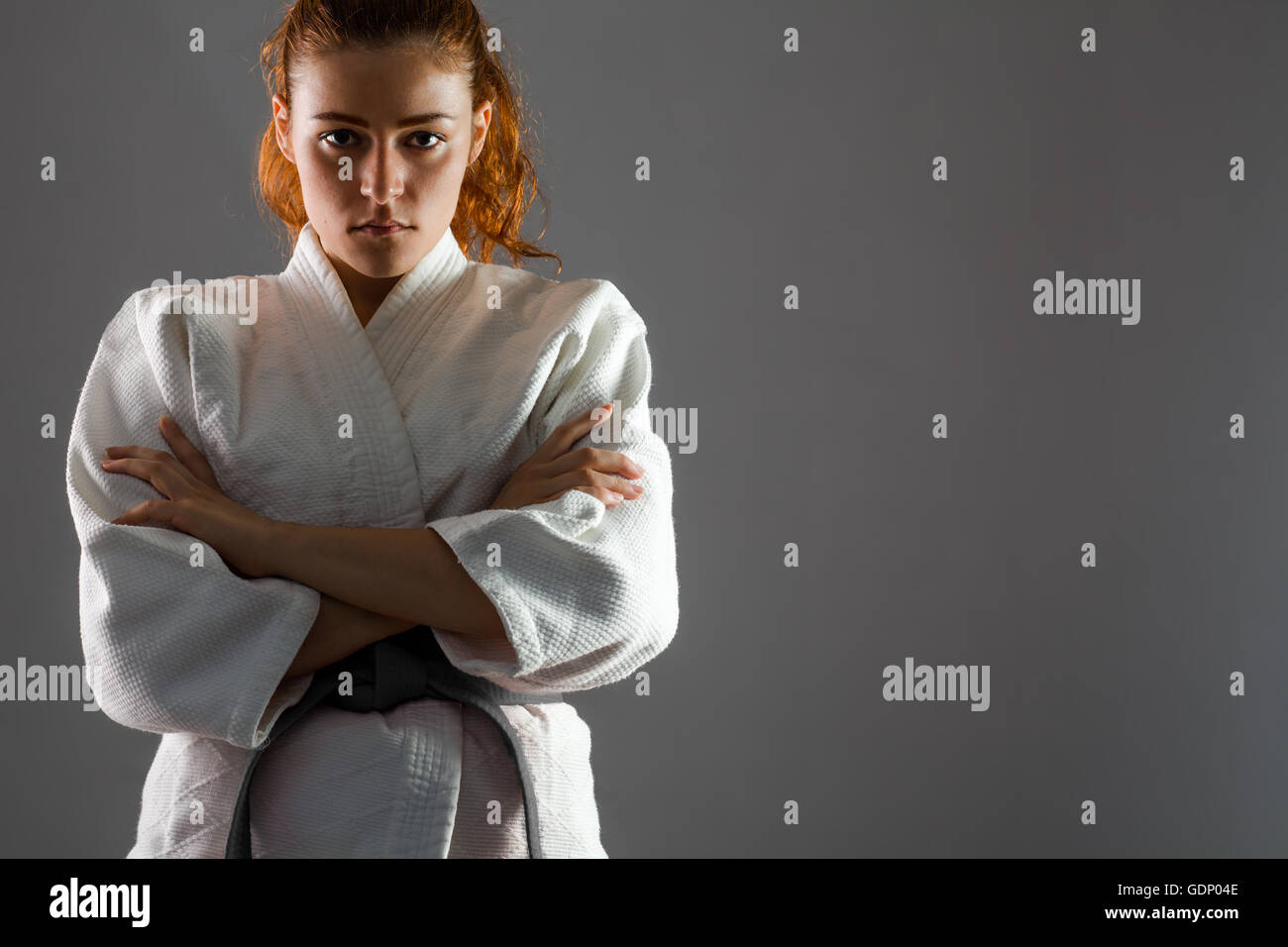 Confident Woman Wearing Karate Kimono with Crossed Arms Stock Photo