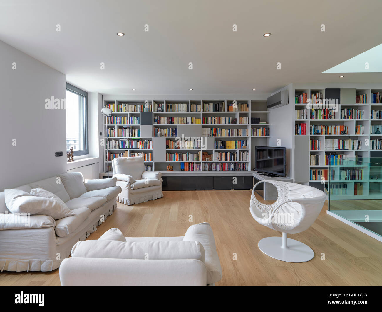 interior view of a modern living room with large bookcase and wooden ...