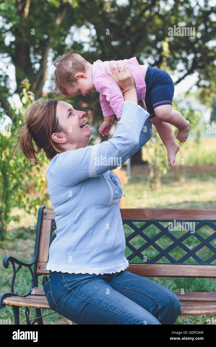 Mom playing with her little daughter in the garden Stock Photo