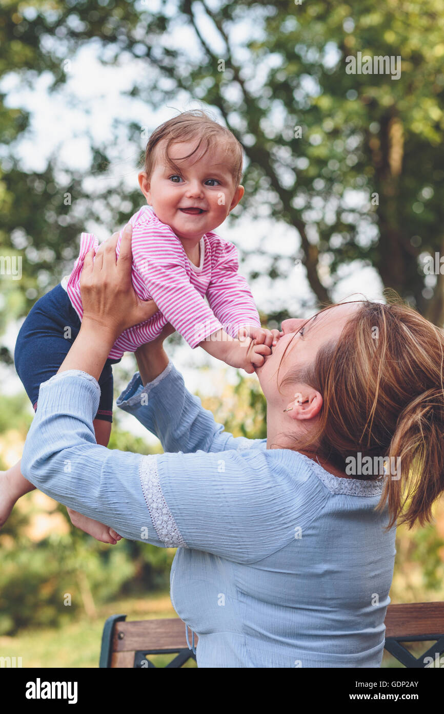 Mom playing with her little daughter in the garden Stock Photo