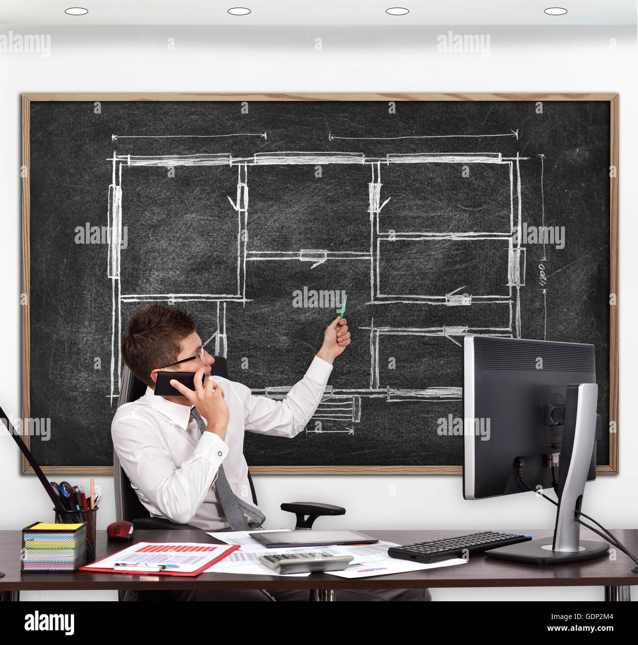 teacher in classroom pointing to blackboard with drawing blueprint Stock Photo