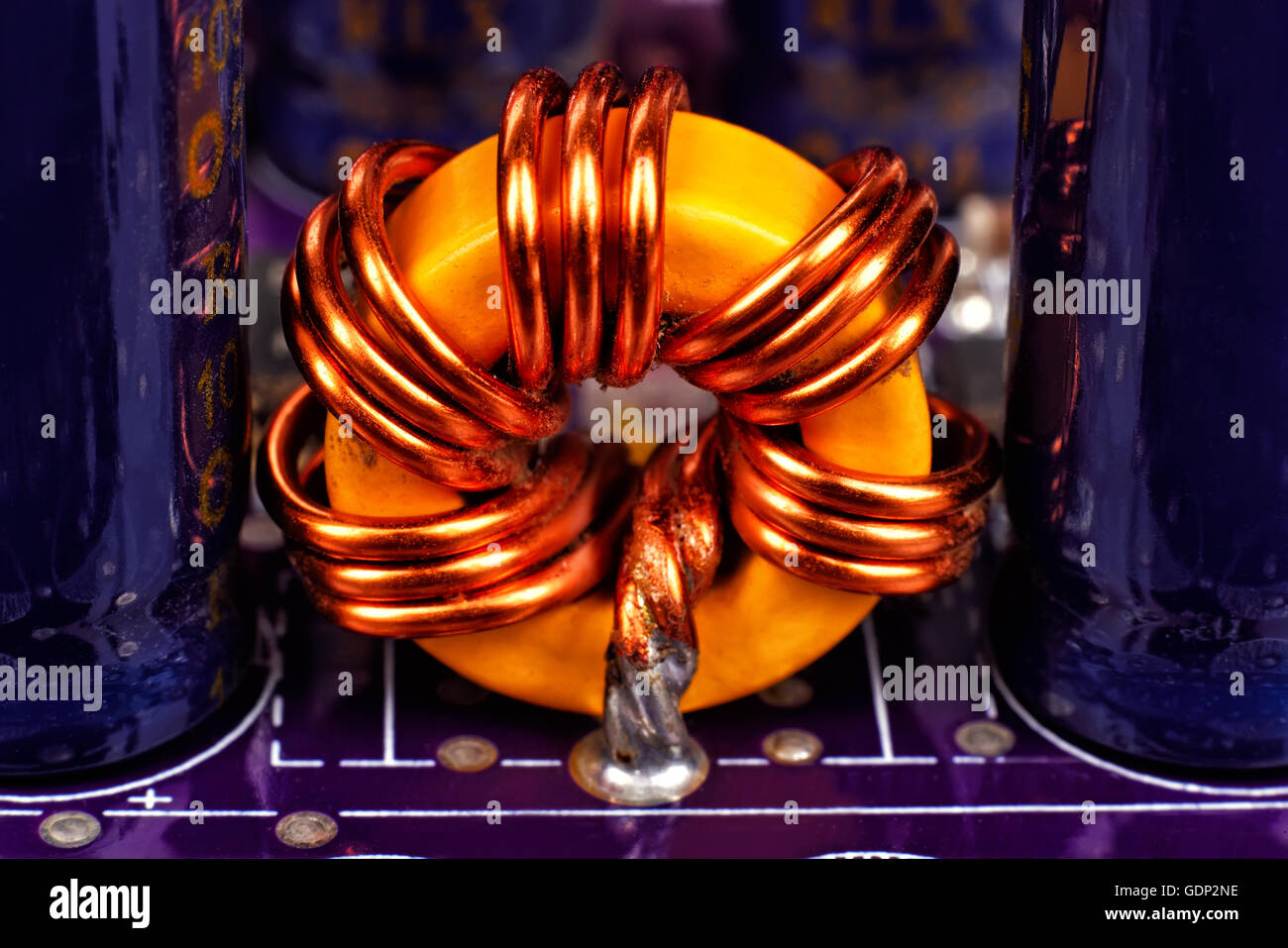 ferrite ring on purple circuit board, close up Stock Photo